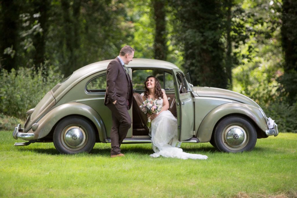 Bride and Groom (Jess & Si) drive their green vintage VW into the castle woodlands for photographs