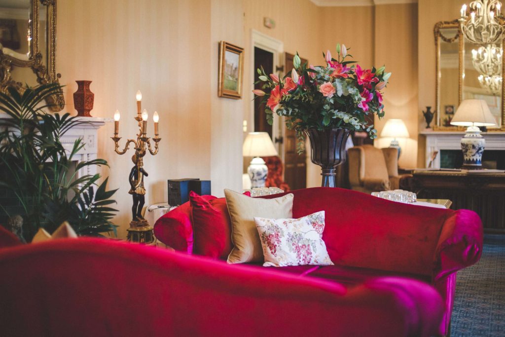 A corner of the castle lounge is shown here with its sumptuous velvet pink sofa and gold and floral cushions