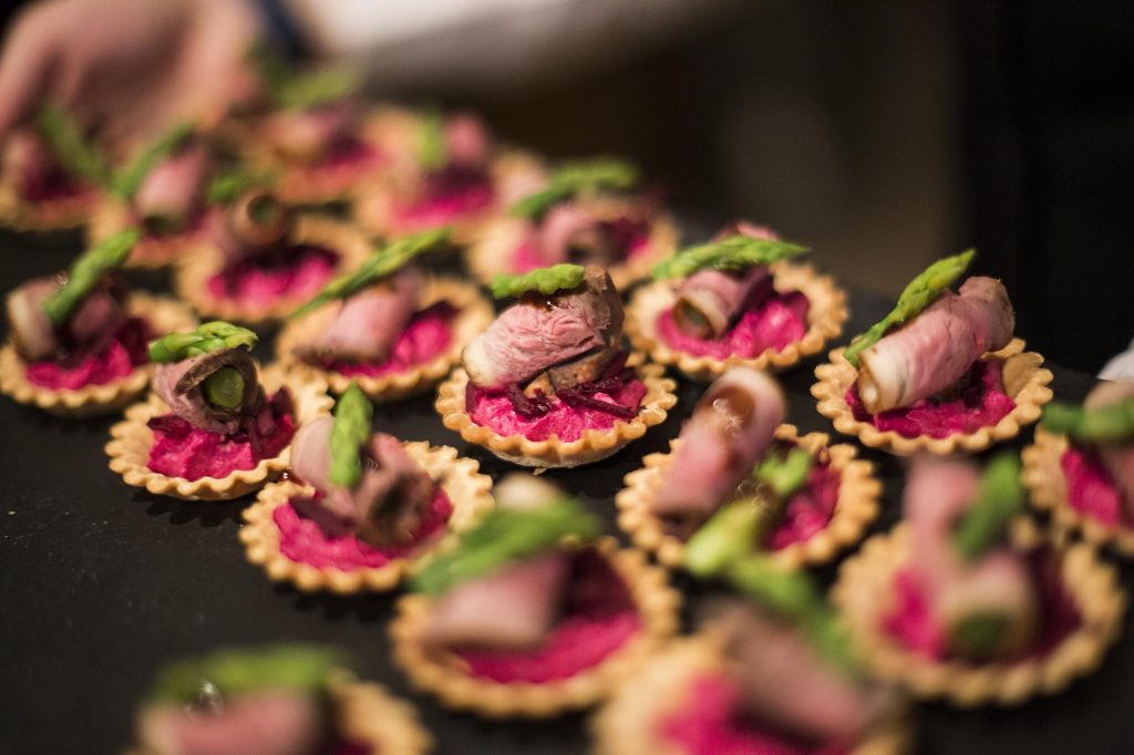Vibrant beef, beetroot and asparagus canapes are photographed up close