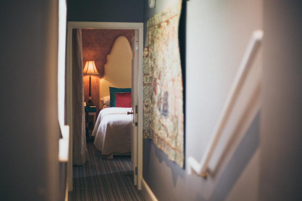 The Corridor to the Lord William Twin Bedroom. A wall hanging tapestry and a peak of the twin room can be seen