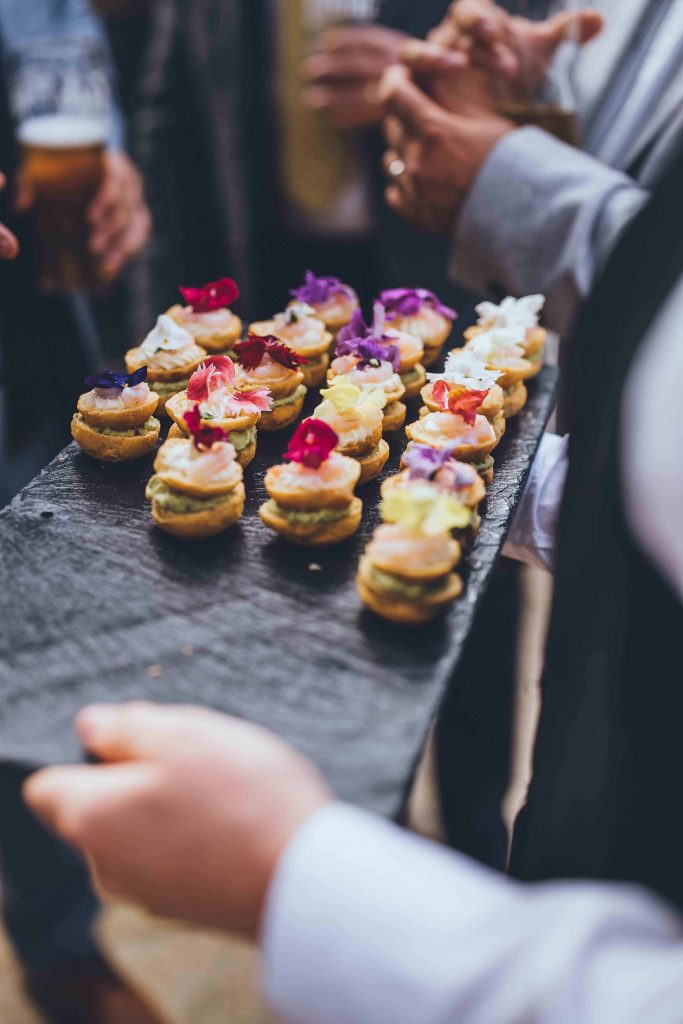 Food and Beverage team member Dani circulates with canapes served from a slate platter
