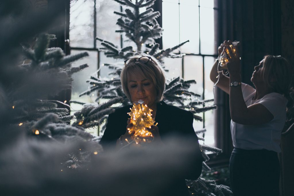 Sales team members Karen and Lorraine dress christmas trees with fairy lights