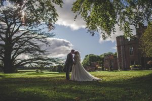 Bride and Groom's first kiss in front of romantic Rowton Castle