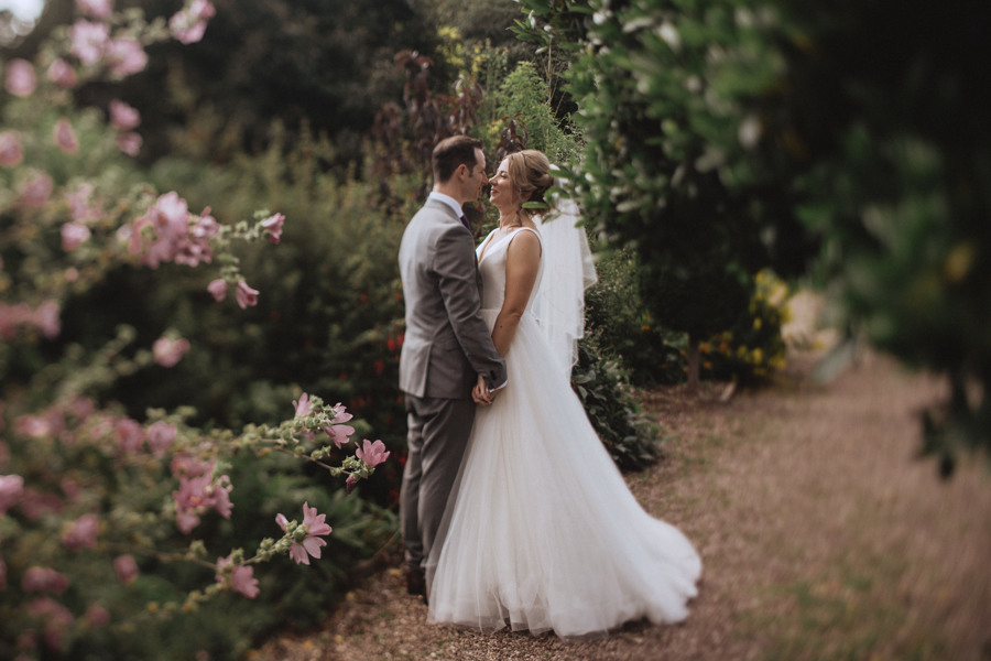 The bride and groom embrace in the secret gardens at Rowton Castle