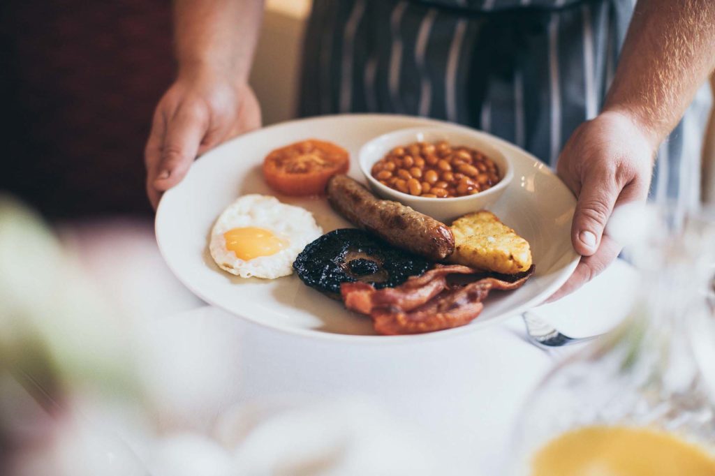 Chef is photographed holding full english breakfast