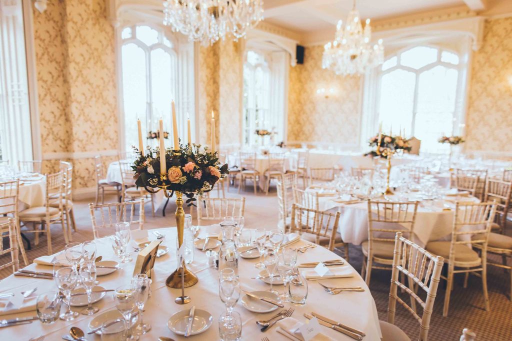 The Cardeston Suite (at Rowton Castle Wedding Venue) is all set for a Grand Wedding Breakfast with Pink Florals and Gold Candelabras