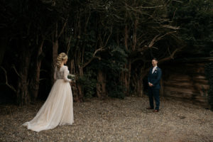 The bride and groom enjoy a first look alone in the castle woodland