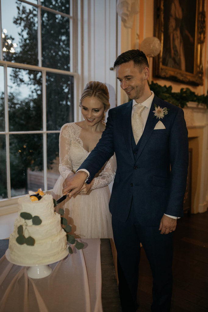 Taylor and Chris (our Bride and Groom) are pictured cutting their wedding cake in front of the window in their Wedding Breakfast room