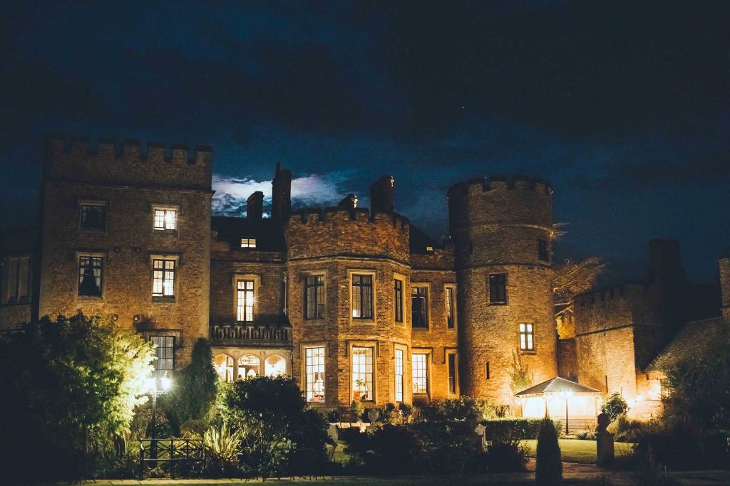 The rear of the castle has been photographed at night from the gardens. The garden lights are on