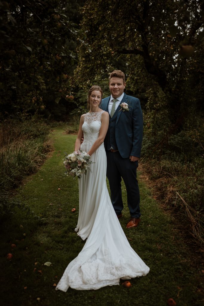 Bride and Groom pose for photographs in the castle woodland on an autumn day