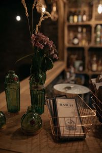 Close up of menus and drinks bottles atop Bar. 97