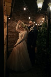 The Bride and Groom dance under the string lights of outdoor Bar. 97
