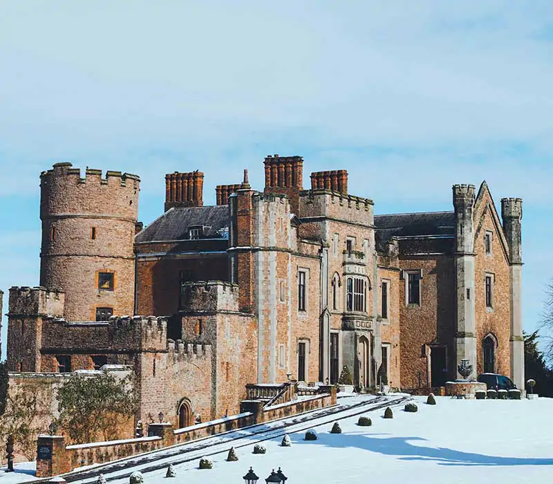 Exterior of Rowton Castle covered in snow, showcasing the historic castle as a magical winter wedding venue in Shropshire.