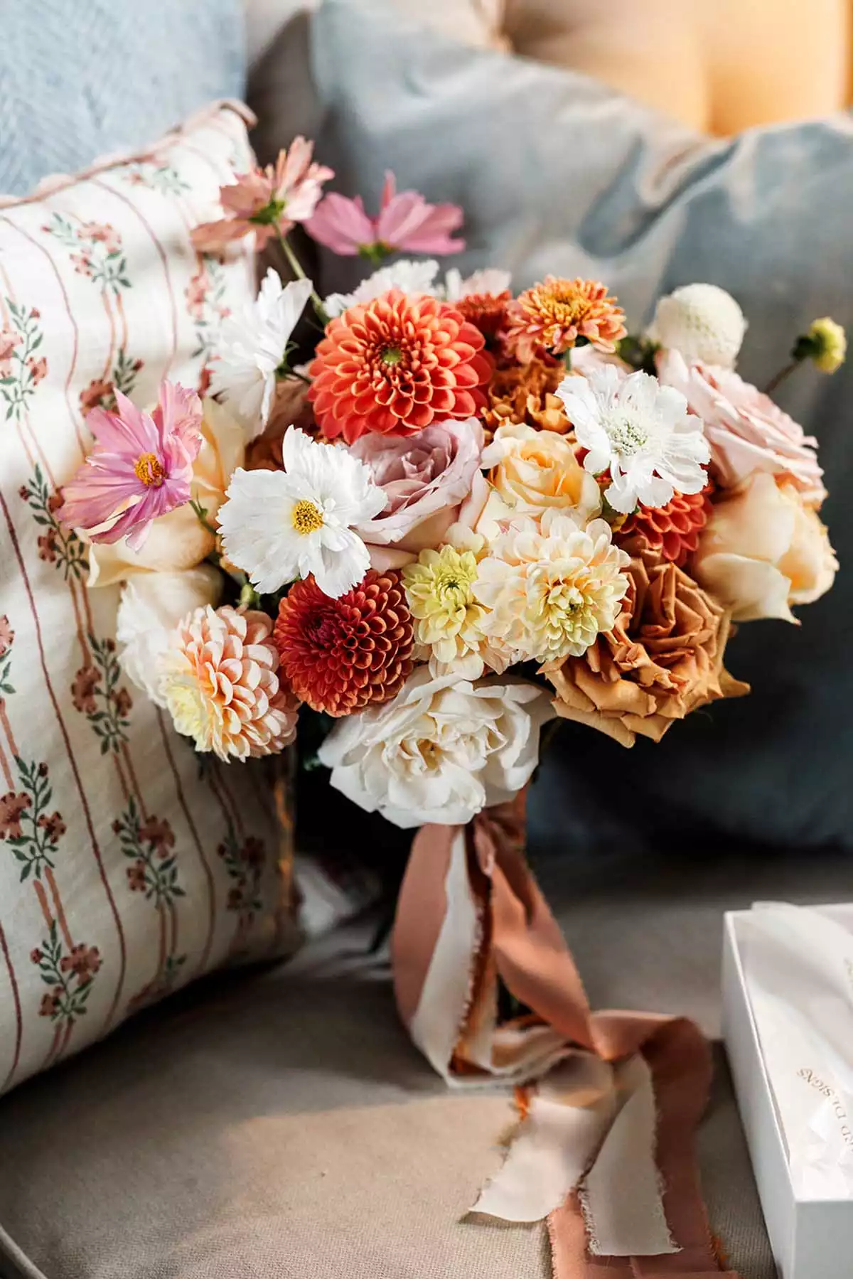 Wedding bouquet resting on a sofa during bridal preparations