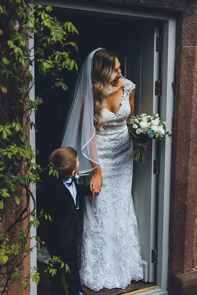 Bride holding hands with a young child before the ceremony