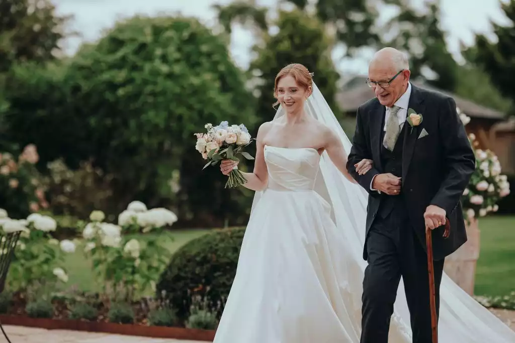 Bride walking with her father through the gardens before her Rowton Castle wedding ceremony